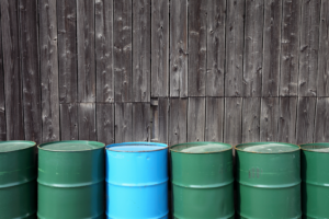 Green and blue barrels against a wooden wall