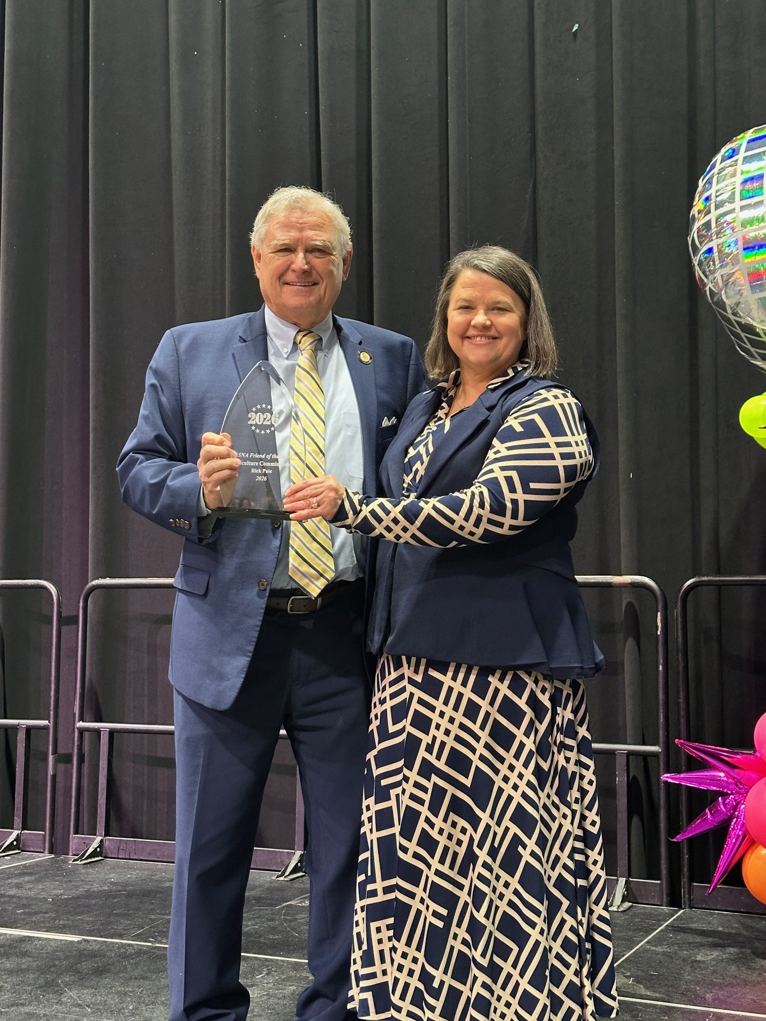 Commissioner Rick Pate accepts the Friend of the Year award from Alabama School Nutrition Association (ASNA) President Cacyce R. Davis.